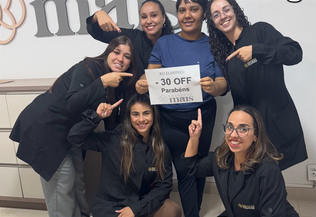 Cliente segurando a placa EU ELIMINEI 30 kg, o recorde da casa da Emagreça Mais